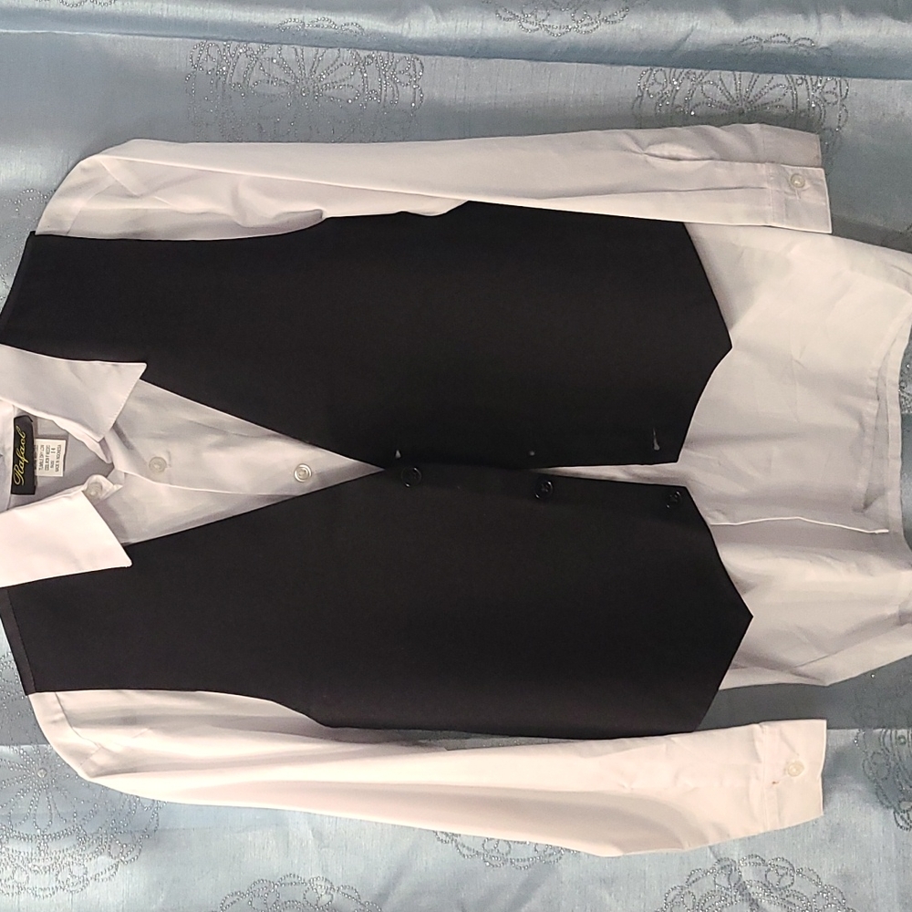 Boys black suit with white dress shirt vest tie and black pants.